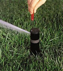 a Richland Hills irrigation repair tech is doing a sprinkler head adjustement